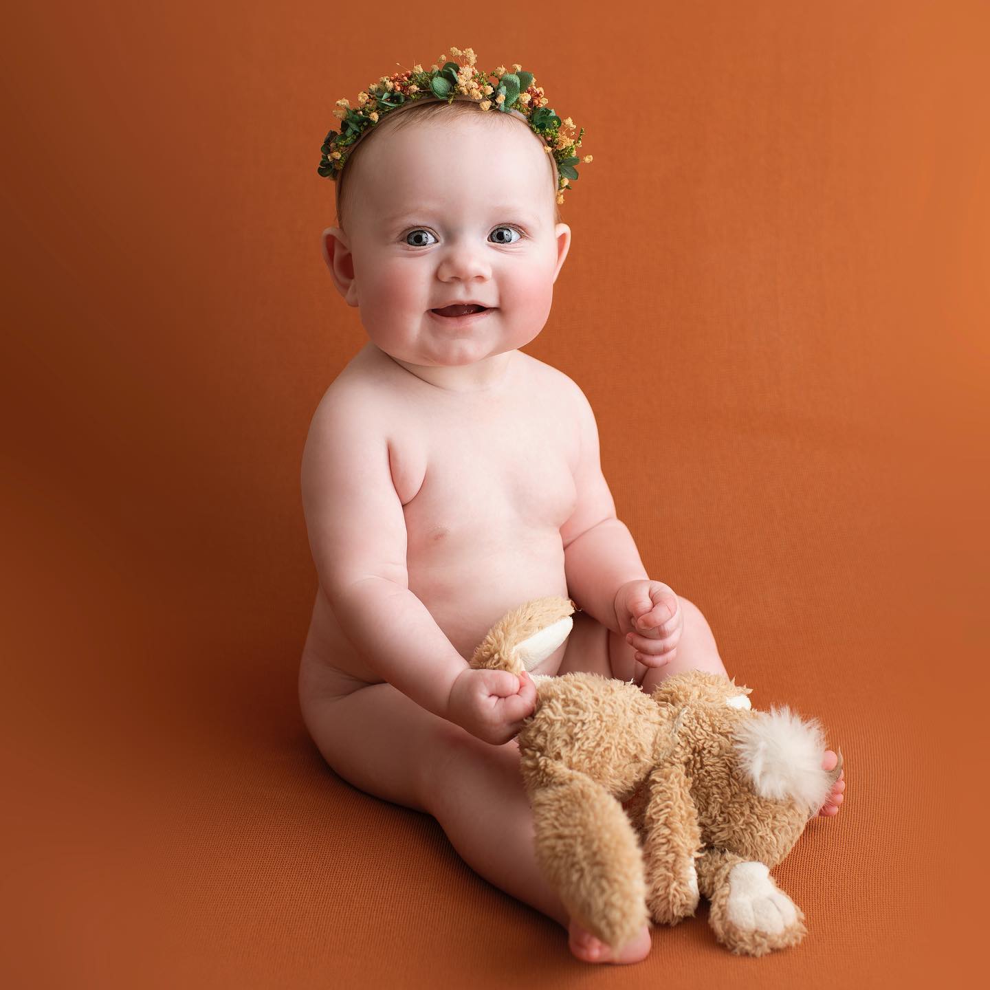 Barnporträtt på orange bakgrund i fotostudion.