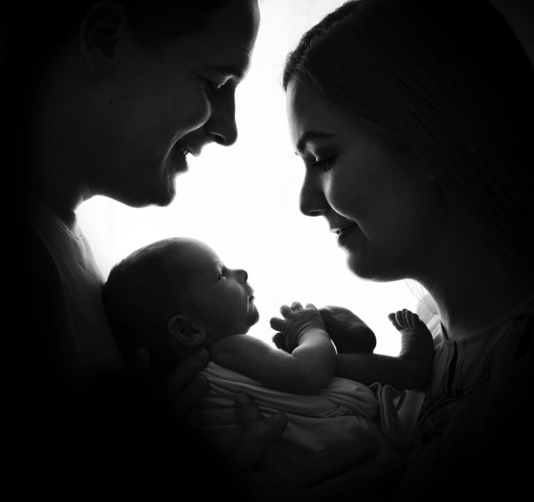 Svartvitt familjeporträtt med en nyfödd liten bebis.