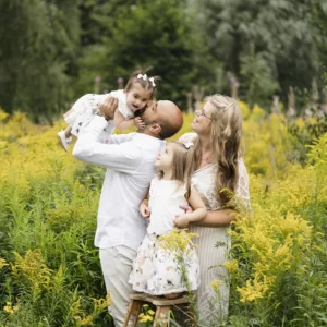 Familjebild där pappa pussar lillasyster