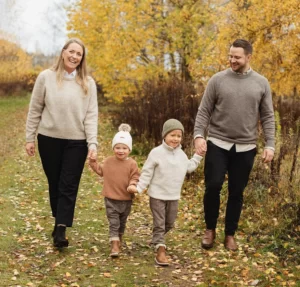 Familjeporträtt med en familj som går hand i hand på hösten.