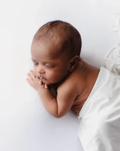 En bild på ett nyfött barn som ligger och sover under sin fotografering. 