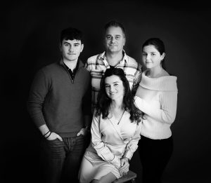 Familjeporträtt på svart bakgrund i fotostudio i Skaraborg.