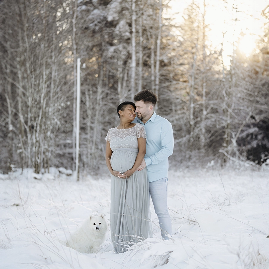 Gravidfotografering utomhus i vinterlandskap med hund.