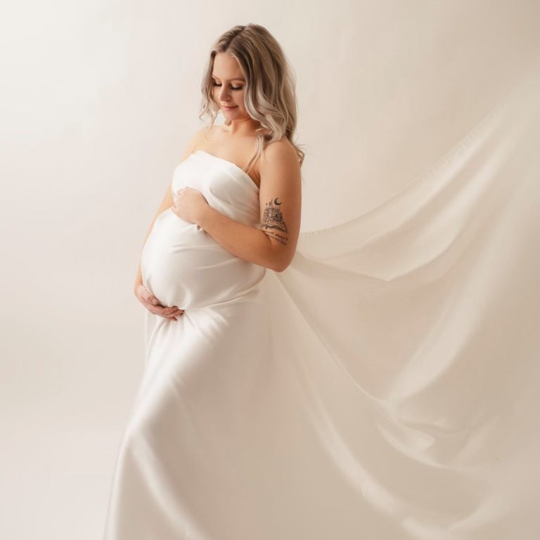 Gravidporträtt fotat i fotostudion på vit bakgrund.