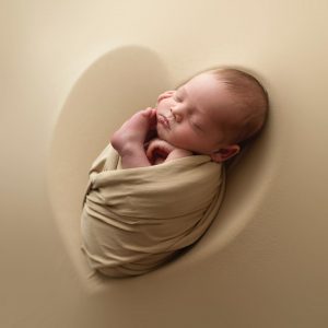 Nyföddfotografering med Joey på beige bakgrund.