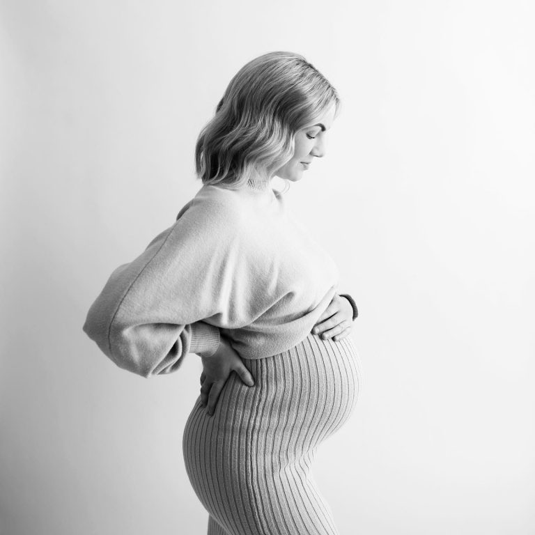 Ett svartvitt gravidporträtt taget i fotostudion.