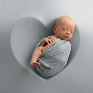 Nyfödd bebis i en hjärtformad skål.